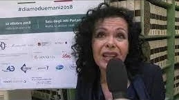 Palma Marino Aimone intervistata al convegno «Diamo due mani», il 12 ottobre 2018, davanti al cartello dell’evento.